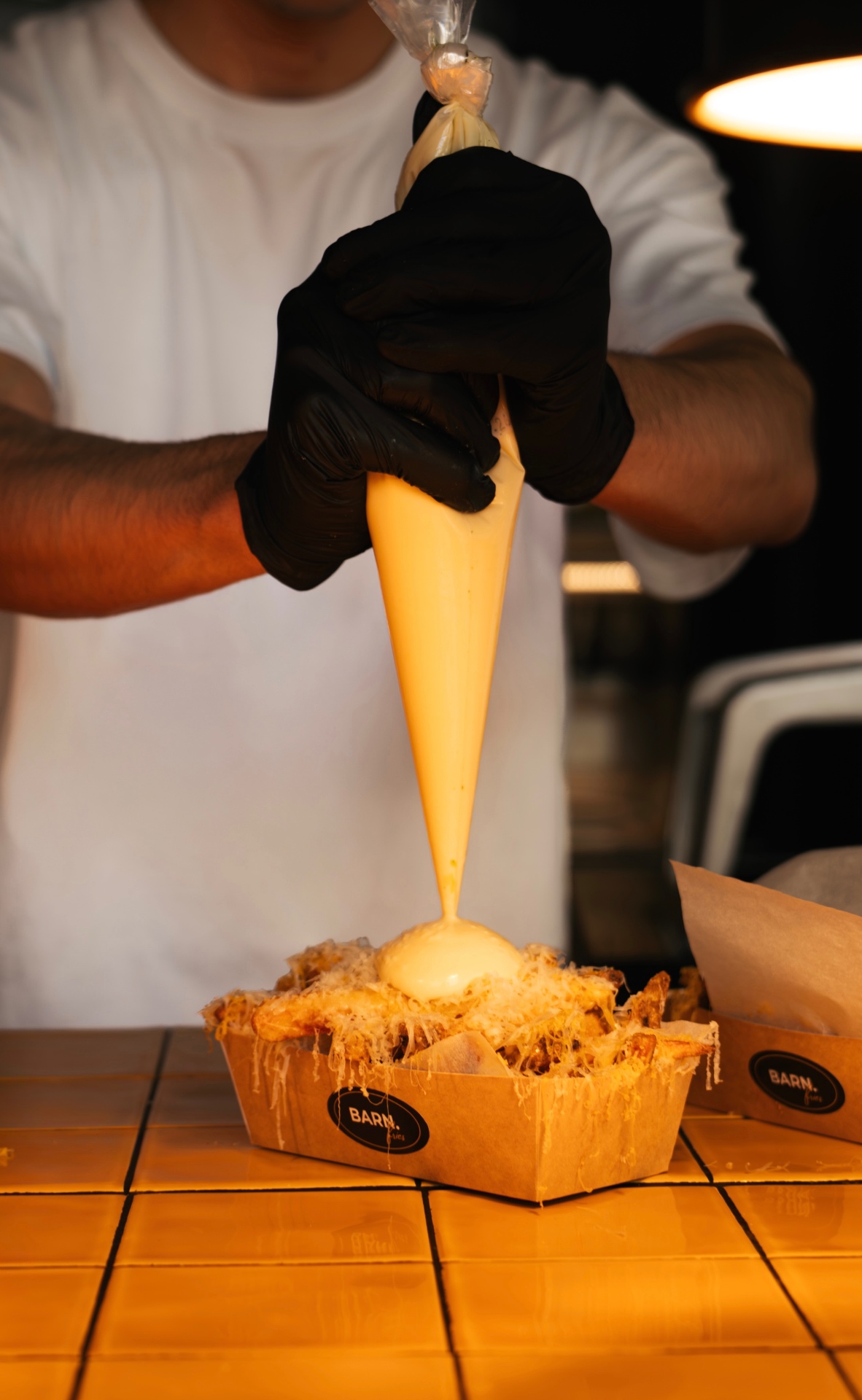 Molten cheese sauce piped over crispy fries